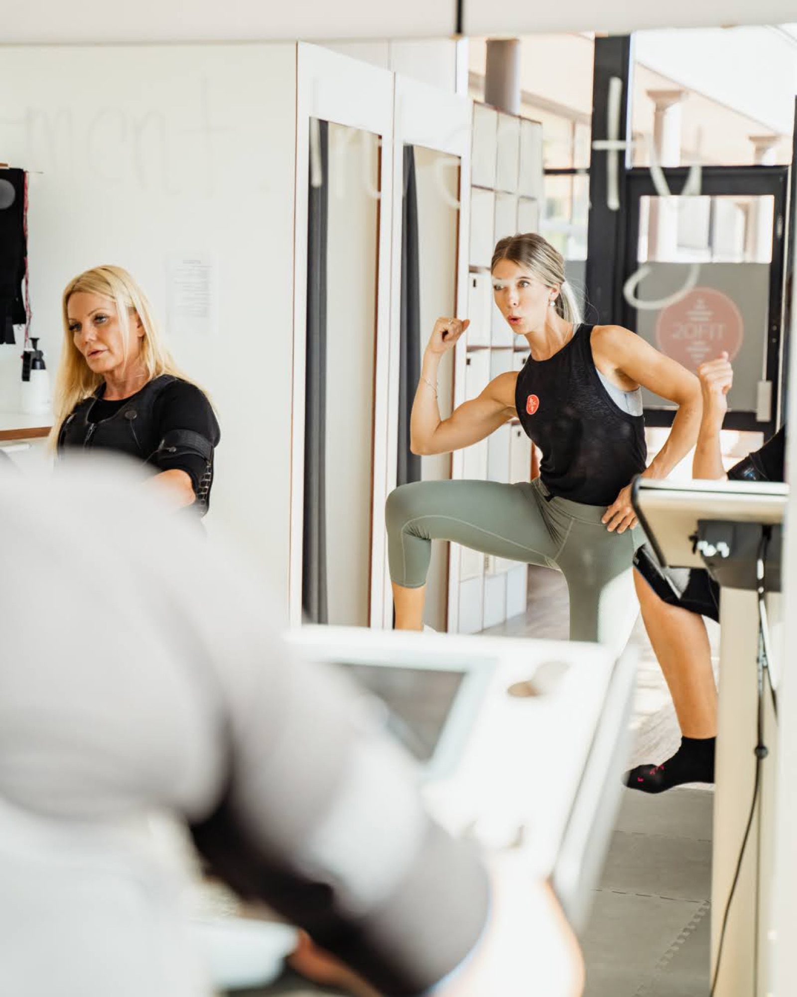 Woman throwing a punch by the mirror in an EMS suit